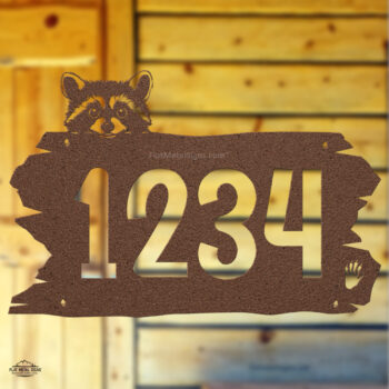 Rustic metal raccoon head address sign mounted on cabin wall