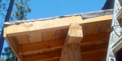 Exposed rafter ends and roofing felt before the sawmill trimming was installed on the awning.