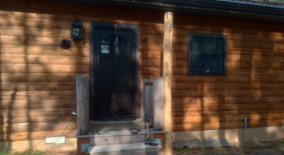 Peeled pine log post installed for a new back porch awning at a log home