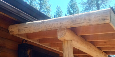 Rustic sawmill trimming installed on the end of the back door awning, matching the log beam and support posts. It has bcome part of the log cabin awning.