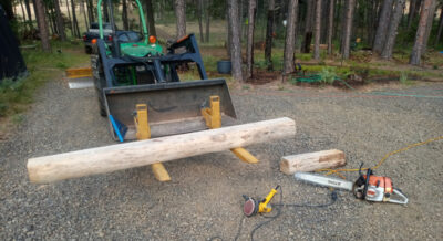 Sanded pine beam ready to be moved by tractor for a log home porch awning.